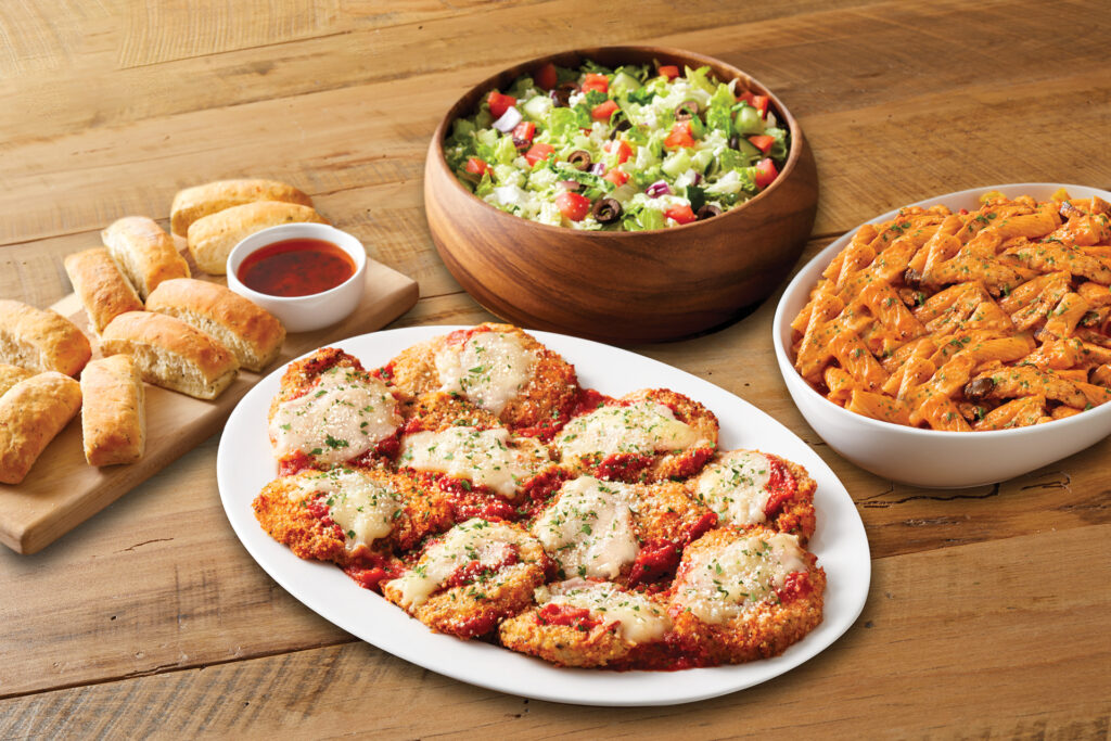 Bravo's group dining spread with fra diavolo, chicken parmesan, chopped salad, bread