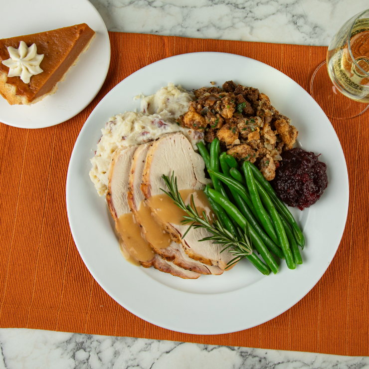 A plate of turkey, stuffing, and greens from Bravo