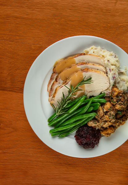 A plate of Thanksgiving turkey, greens and stuffing from Bravo