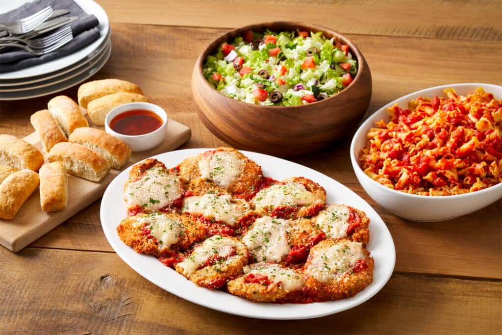 Group dining package including salad, pasta, chicken parmesan, and freshly baked bread